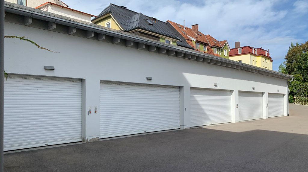 Mehrere nebeneinander liegende Garagen in einer Wohngegend, die jeweils mit einem Garagentorantrieb ausgestattet sind