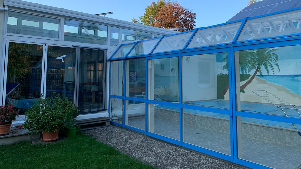 Wintergartenkonstruktion aus blauem und weißem Kunststoff und Glas, dessen Steuerungseinheit von Elektro Beck eingebaut wurde